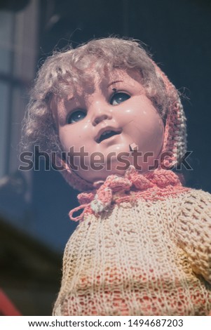 vintage porcelain baby dolls in simple clothes in a shop window, selective focus.
