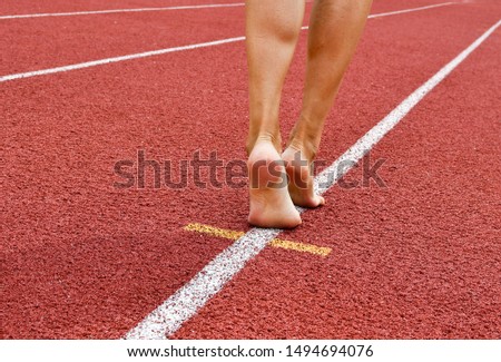 Feet of woman on a white line of the track athletics - concept of marketing business and sales increase