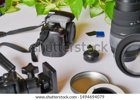 Photography instruments as camera body and lens and SD cards and photographic stand and ND filter on the white background