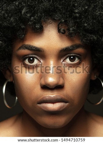 Close up portrait of young and emotional african-american woman. Highly detail photoshot of female model with well-kept skin and bright facial expression. Concept of human emotions. Looking at camera.