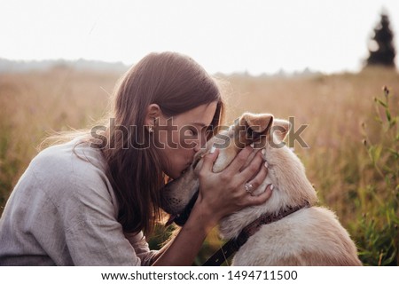 Human and a dog. Girl and her friend dog on the straw field background. Beautiful young woman relaxed and carefree enjoying a summer sunset with her lovely dog Royalty-Free Stock Photo #1494711500