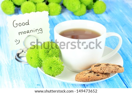 Beautiful green chrysanthemum with cup of tea on table close-up