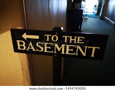 A sign which points to the basement where you can access the cellar and undergound areas
