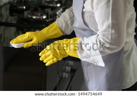asian middle aged domestic helper woman cleaning kitchen, doing housework, housekeeping service concept Royalty-Free Stock Photo #1494754649
