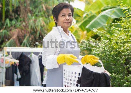 middle aged asian woman doing laundry work, washing cloth Royalty-Free Stock Photo #1494754769