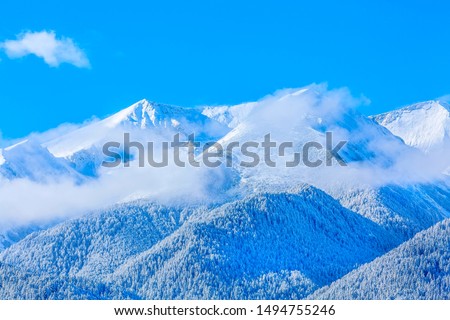 Winter Pirin mountains travel vacation nature panoramic background with snow covered mountain peaks and blue sky with clouds closeup Royalty-Free Stock Photo #1494755246