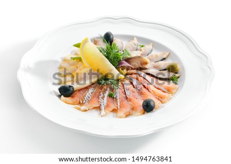 Macro shot of elegant restaurant plate with salted smoked salmon, sliced mackerel and butter fish isolated. Raw assorted fish delicacies or sashimi decorated with fresh herbs and olives closeup Royalty-Free Stock Photo #1494763841