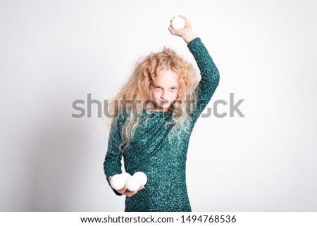 Merry Christmas and happy new year! happy girl with snow balls in hands looks very angry. Close portrait isolated on white background. Girl throw snowball 