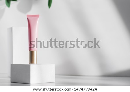 Natural cosmetic lotion tube mock up side view. Eco friendly cosmetology banner concept with copyspace. Organic skincare product close up. Pink moisturizing lotion container, female hygiene accessory Royalty-Free Stock Photo #1494799424