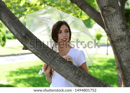 young woman holds an umbrella transparent by a tree autumn park rain september
