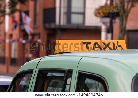 A taxi sign with a disable - wheelchair symbol in Belfast, Northern Ireland, UK.
