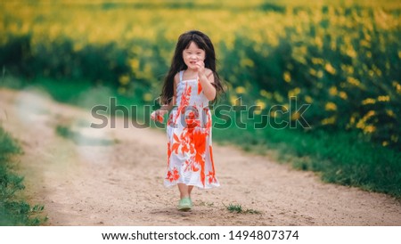 Happy little asian girl in flower field