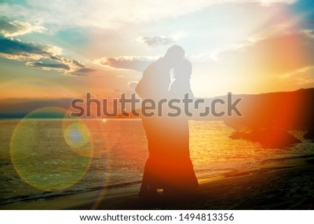 happy couple silhouette by the Greek sea on the shore background