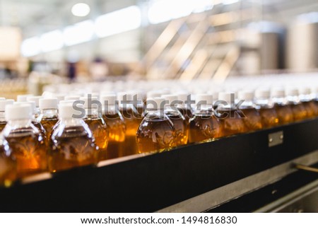 Bottling factory - Apple juice bottling line for processing and bottling juice into bottles. Selective focus.  Royalty-Free Stock Photo #1494816830
