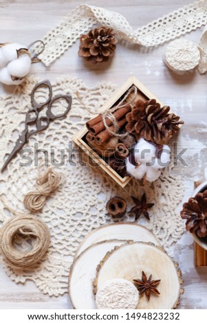 Time to wrap christmas presents! Ideas for hand made gifts decoration in rustic style, natural ingredients, cozy mood. Wooden background, scissors, rope, lace, cones, cinnamon and cotton. Flat lay.