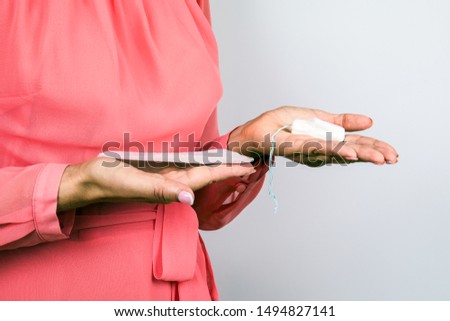 Female hygiene, secretions and menstruation protection. Woman holds sanitary pad and tampon