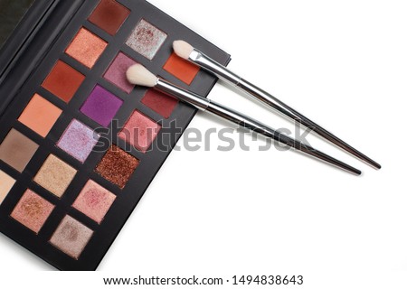 Eyeshadow palette of orange colors with brushes against white background. Empty space