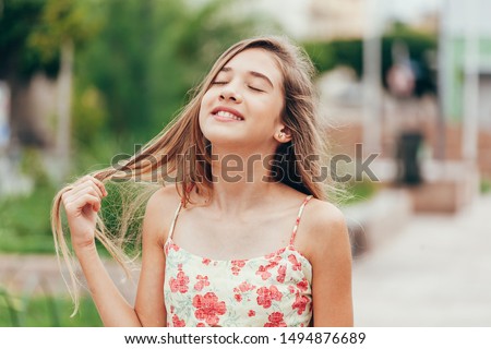 Outdoor portrait of 12 years old girl with long hair