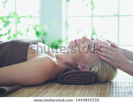 Beautiful woman doing facial massage in a spa salon