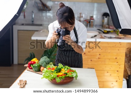 photographer food , asian women is taking pictures of food her food in studio.