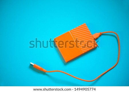Close up of orange external hard disk drive for connect to laptop, transfer or backup data between computer and HDD. 