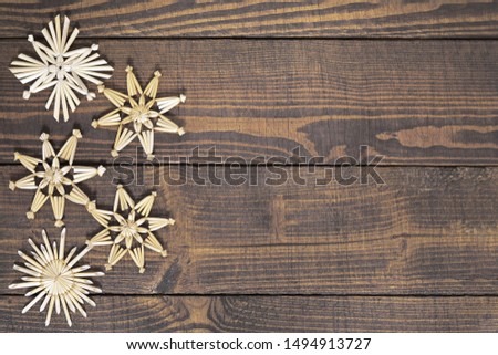 Straw Christmas ornaments on wooden background  