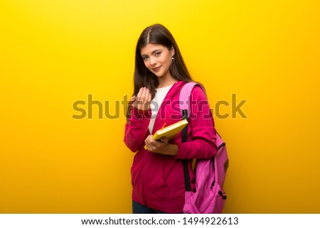 Teenager student girl on vibrant yellow background presenting and inviting to come