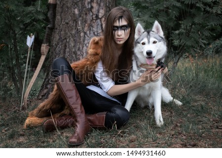 Art photo of a girl hunters with a bow and a husky on a halt