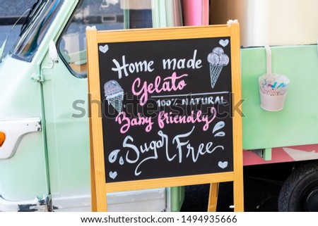 Gluten free, lactose free, gluten free ice cream sign. Advertisement on chalk board during food festival. Vintage retro italian car behind the sign. intolerance free dessert shop directional ad text