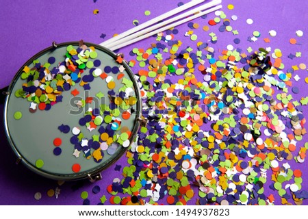 Colorful confetti, used in carnival.Tamborim instrument used in street blocks, parade school of samba.A lilac background.View from the top. Royalty-Free Stock Photo #1494937823