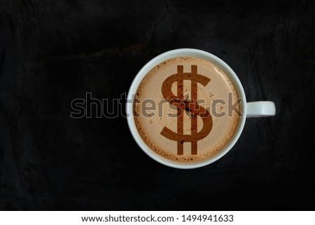 white cup with cappuccino and foam in the form of a picture dollar, top view, close-up, copy space
