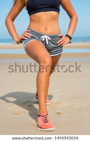beautiful athletic young woman doing exercises on the beach