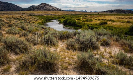 Sweetwater River in the Granite Mountains of Wyoming with sagebrush, sand, and flowing water Royalty-Free Stock Photo #1494989675