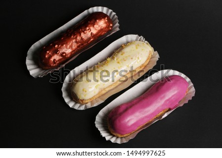 Eclair french cake delicious dessert on black background close up food photo