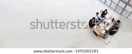Top view of group of multiethnic busy people working in an office, Aerial view with businessman and businesswoman sitting around a conference table with blank copy space, Business meeting concept Royalty-Free Stock Photo #1495002581