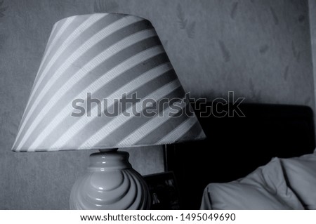 alone in a hotel room with a lamp turned off