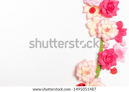 Frame made of rose flowers on white background. Top view with copy space. Flat lay design concept.