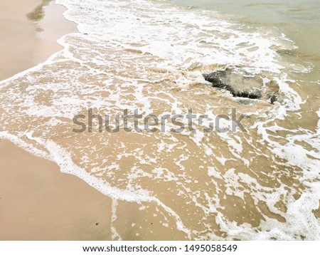Nature background with sandy beach, ocean waves on sandy beach, background for text, sea background