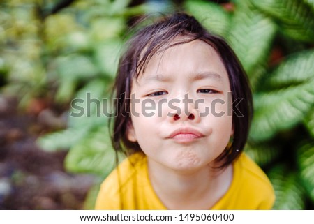 Confused face and bored face.little 5 years old asian girl scratch on head and show confuse face.Boring face in the jungle.