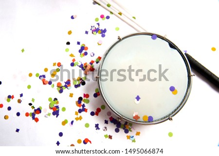 Tambourine, with chopped, colorful confetti, used in the carnival. Popular party of samba. Instrument used in street blocks, parade of samba school. White background. From above.Space for your text. Royalty-Free Stock Photo #1495066874