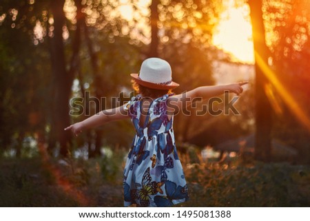 Portrait of a beautiful girl in hat at sunset, a child in the sun, child portrait close-up