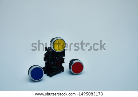 Switches and buttons start-stop red green yellow blue on white background.Button for industrial machine.