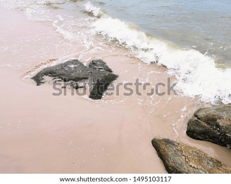 Nature background with sandy beach, sea waves on sandy beach, background for text, sea background and stone.