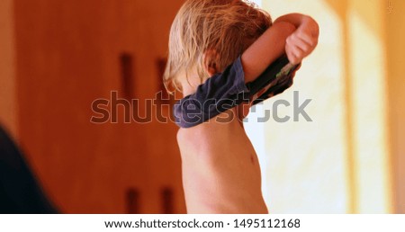 
Little boy getting dressed kid putting and removing t-shirt