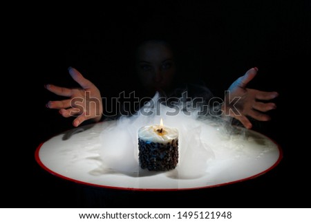 Magic and tricks. Passes with hands around the smoke. Still life. Creative photography for advertising tricks. Show with the use of blue smoke. Wizard. Burning candle Beautiful picture for wallpaper