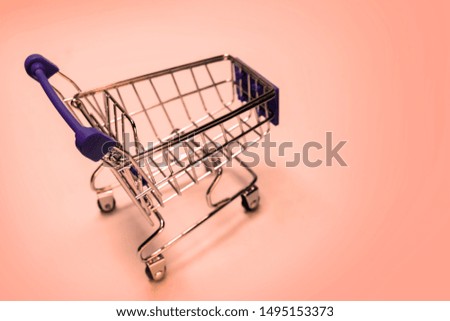 Shopping cart on a pink background. Concept festive sale online, Christmas and New Year discounts, black friday., level of consumer basket, Copy space.