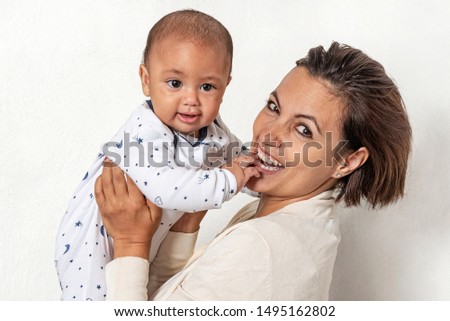Mother lifting and playing with her newborn baby
Immense joy of both son and mother