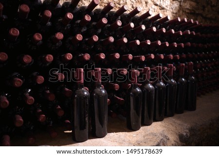 Bottles of expensive sweet red wine. Ancient cellar with expensive wine