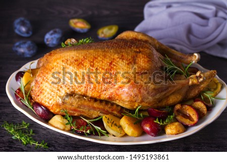 Whole duck with potatoes, plums and herbs