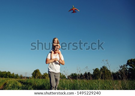 A father and child on meadow with a kite in the summer